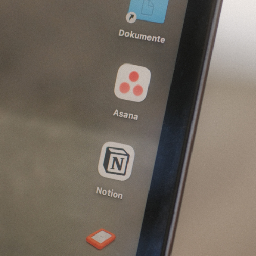 Close-up of a computer screen showing app icons for Asana and Notion.